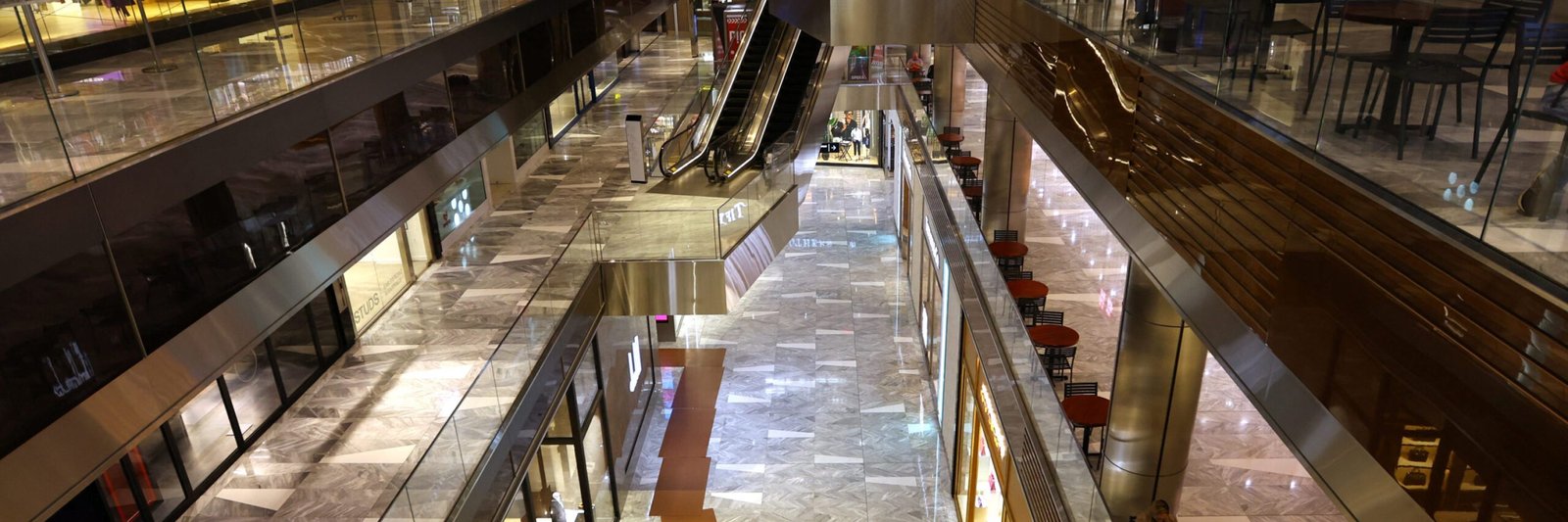 A person walks through a nearly empty area of retail shops inside The Shops & Restaurants at Hudson Yards in Manhattan in New York City, New York, U.S., April 17, 2023. REUTERS/Mike Segar